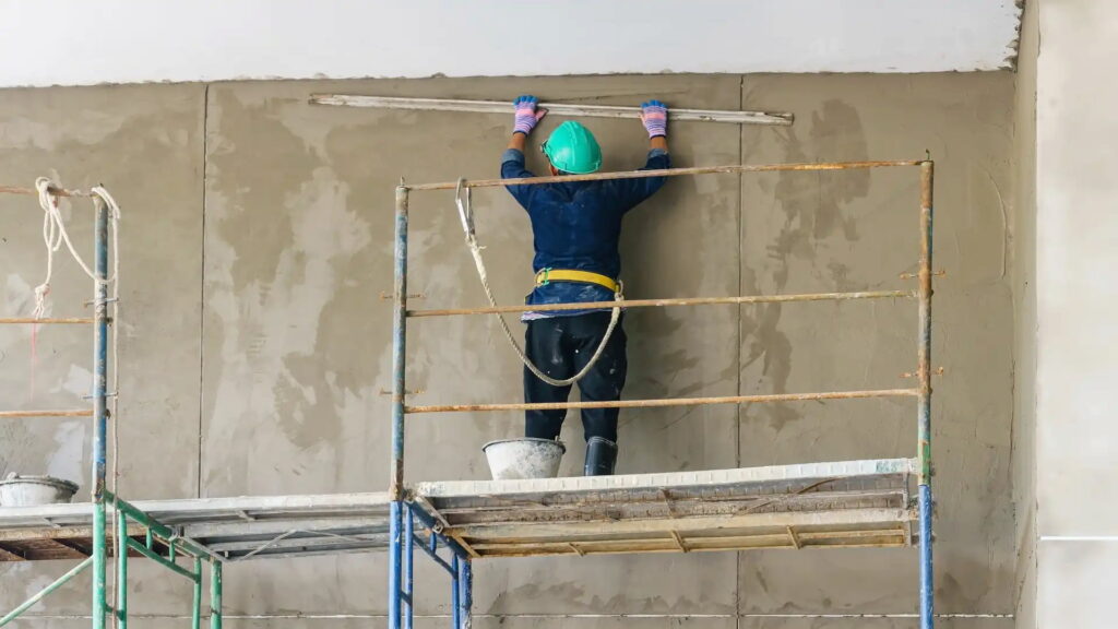 Man on scaffolding - exterior plastering